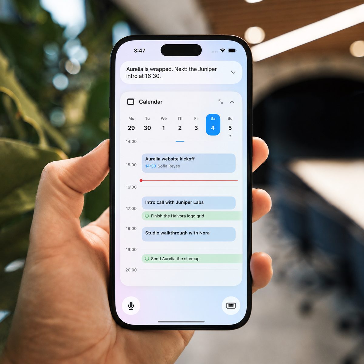 A hand holding an iPhone with the Kinda.Cool calendar for the day